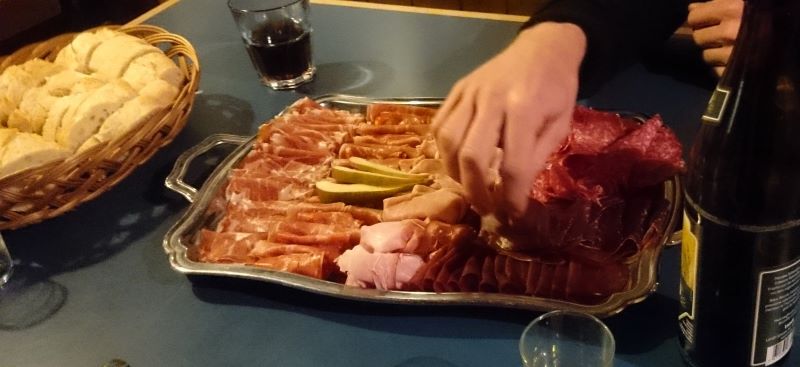 Nahaufnahme der Fleischplättli. Jemand bedient sich gerade.