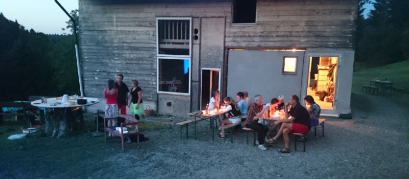 Ein paar Mitglieder sitzen in zivil auf Festbänken. Es wird langsam dunkel.