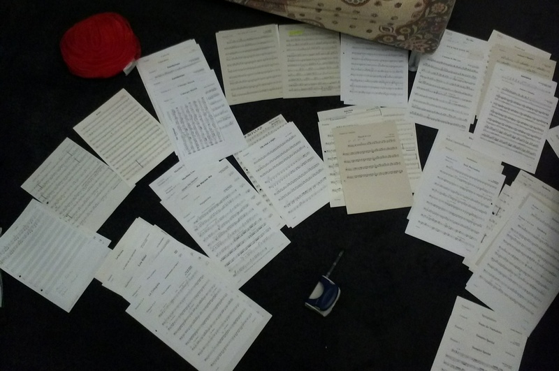 Notenblätter liegen auf dem Boden verteilt um sortiert zu werden.