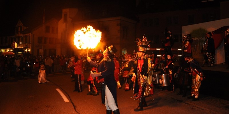 Feuerspucken bei einem Strassenauftritt im Zirkus-Kostüm.